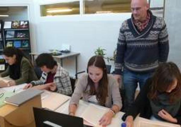 De leerlingen met docent Jurgen Vos aan het werk in de studiezaal