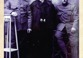 Foto van drie mannen, van wie twee soldaten en één man gekleed in Zuid-Bevelandse streekdracht