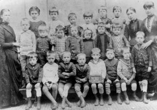 Links op de foto is mej. Hartman te zien met een klas van 5-jarigen in 1887