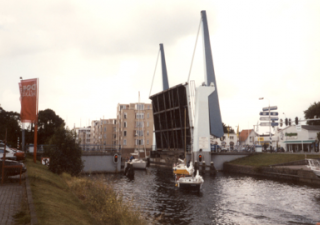 Open brug, twee boten zijn onder de brug gepasseerd en de derde komt eraan