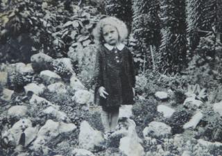Tina als jong meisje in een bloemenveld