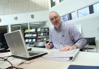 Jan Kouwen in de studiezaal achter zijn laptop