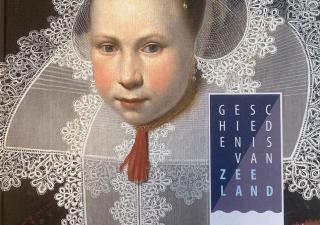 Boek "Geschiedenis van Zeeland" met vrouw in klederdracht op de cover