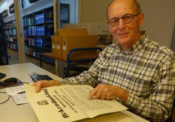 Joost Adriaanse in de raadsledenkamer, bezig aan zijn onderzoek