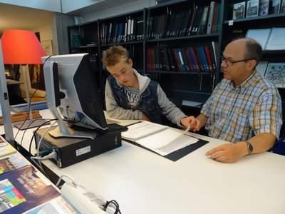 Paul krijgt instructie van archiefmedewerker Jankees Jobse over hoe te zoeken naar de juiste bevolkingsregisters