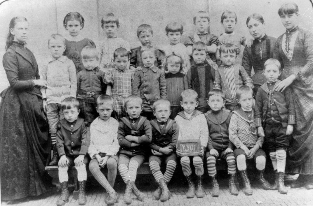Links op de foto is mej. Hartman te zien met een klas van 5-jarigen in 1887