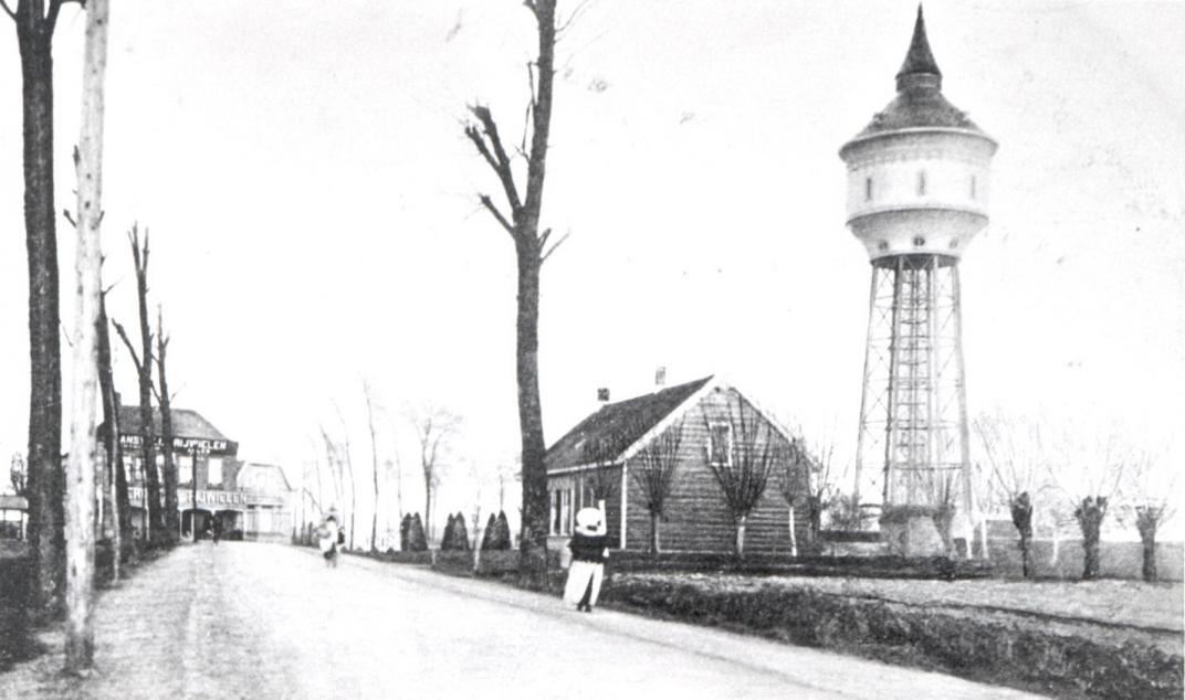 Weg met een paar huizen en de watertoren op de achtergrond