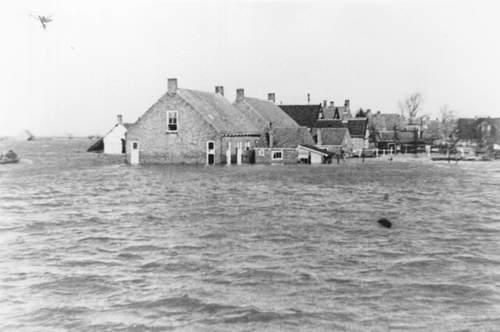 Overstroomd gebied met huizen op de achtergrond