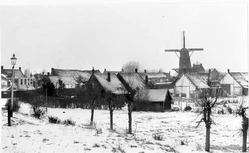 Foto van de Smallegangesbuurt met een molen op de achtergrond