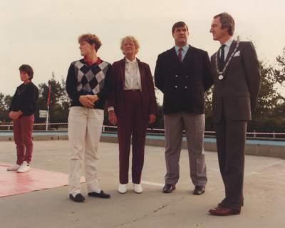 Groep mensen staat buiten op het terrein van de sporthal