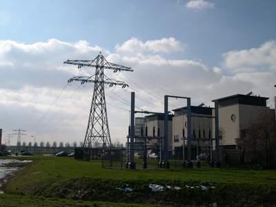 Hoogspanningsmast naast een paar gebouwen