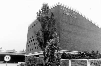 Gebouw van het veilingcomplex met een boom op de voorgrond
