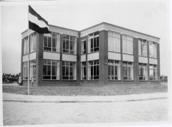 School op de hoek van twee straten. De Nederlandse vlag hangt uit