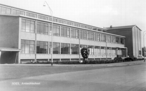 Ambachtsschool aan de Bergweg. Een kunstwerk van een vuist staat op het plein voor de school.