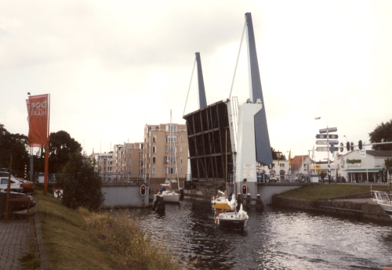 Open brug, twee boten zijn onder de brug gepasseerd en de derde komt eraan
