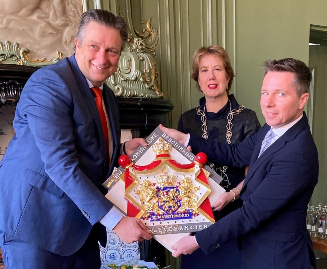 Wethouder Cees Pille, burgemeester Margo Mulder en Cees Bos met het predicaat Hofleverancier
