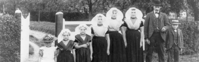 6 vrouwen/meisjes en een man en een jongetje in Zuid-Bevelandse streekdracht