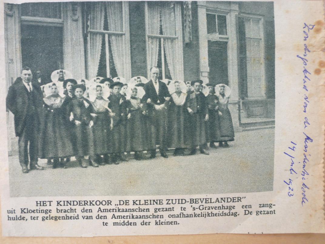 Krantknipsel met foto van kinderkoor. Een groep kinderen staat voor een gebouw. 