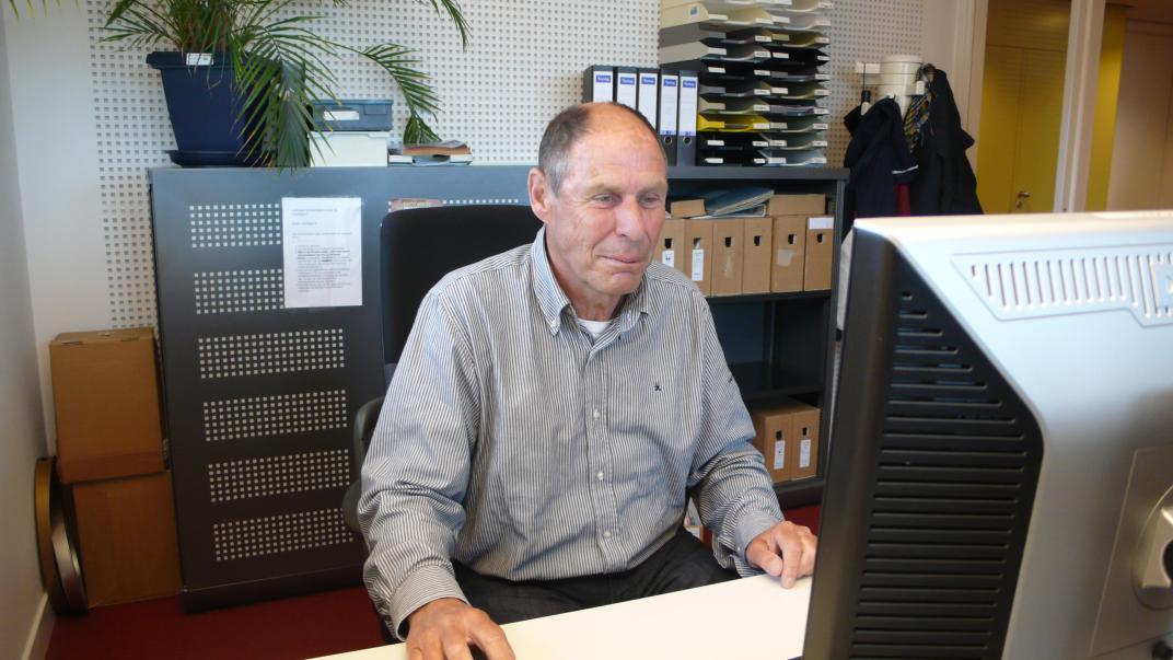 Adri Biersteker zit achter een computer met zijn hand op de muis