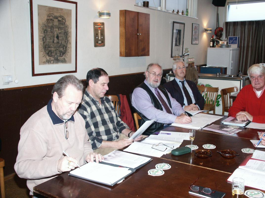 5 mensen zitten aan een tafel