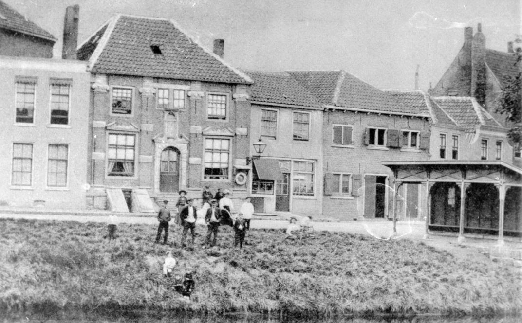 Een groepje mensen staan op een stuk gras aan de J.A. van der Goeskade