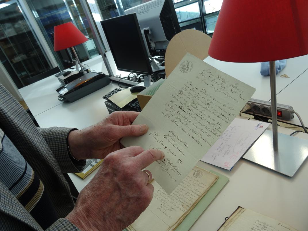 Gerard Lepoeter in de studiezaal, hij houdt een brief vast