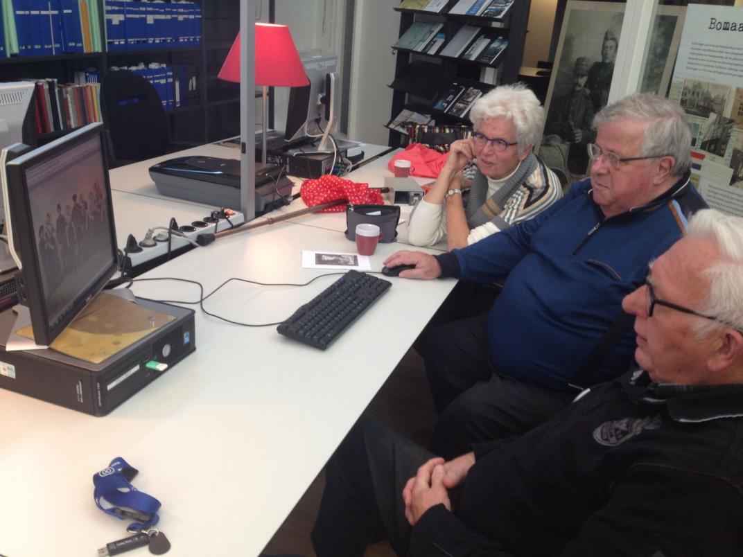 3 vrijwilligers aan een tafel in de studiezaal.