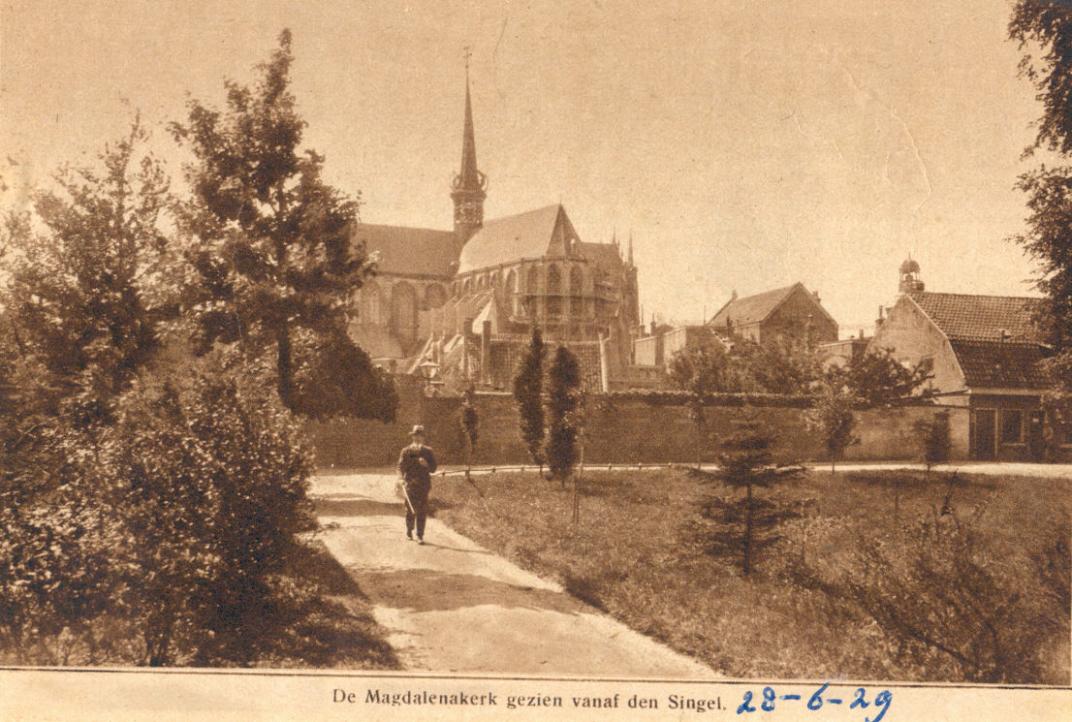 Op de voorgrond een stuk van de Oostwal, daarachter is de Grote of Maria Magdalenakerk te zien
