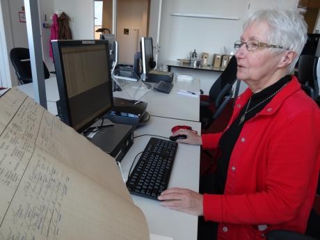 Tannie zit achter een computer met bevolkingsregister voor zich