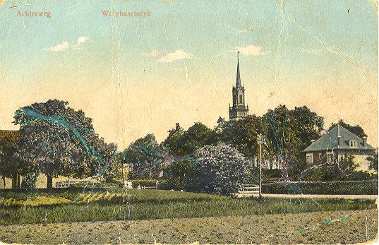 Prentbriefkaart van dorpsgezicht. In de verte is de kerktoren te zien.