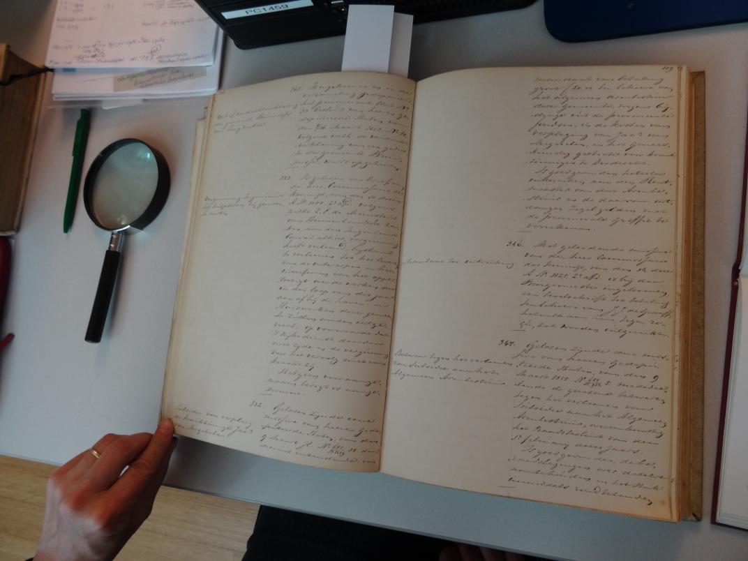 Opengeslagen boek met links een vergrootglas