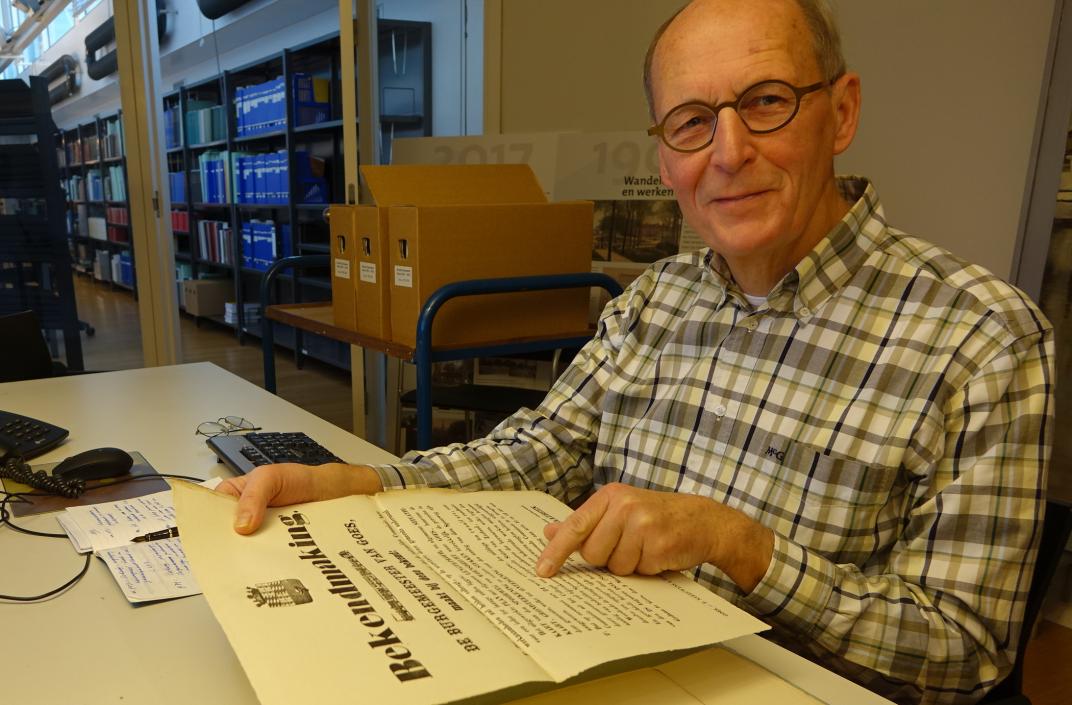 Joost Adriaanse in de raadsledenkamer, bezig aan zijn onderzoek