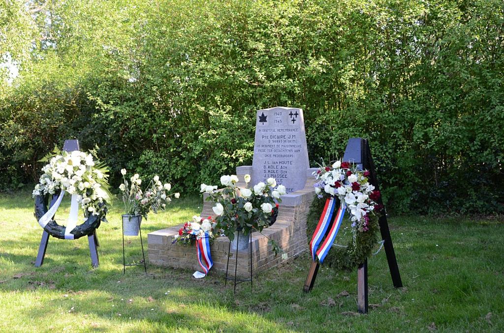 Het oorlogsmonument geflankeerd door 2 kransen