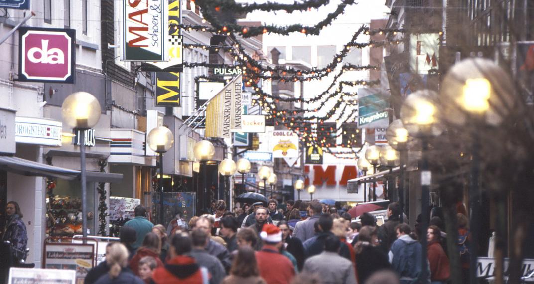 Drukke winkelstraat gedecoreerd met kerstversieringen